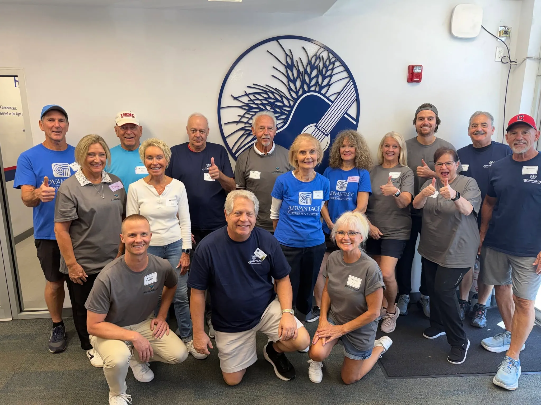 The Advantage Wealth Partners team and friends gathered for a volunteer day at the Harry Chapin Food Bank of Southwest Florida, in front of the food bank's wheat sheaf emblem